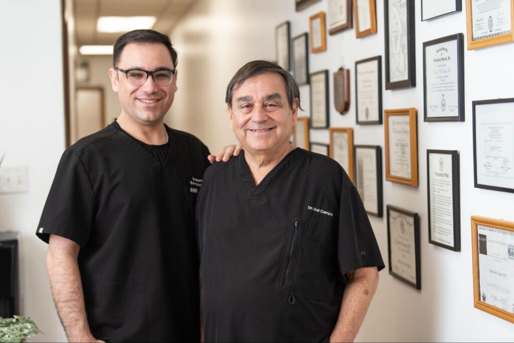 Dr. Danilo Del Campo and Dr. Danny Del Campo, Chicago Skin Clinic dermatologists, in front of a wall displaying medical certifications, emphasizing patient-centered care in dermatology.